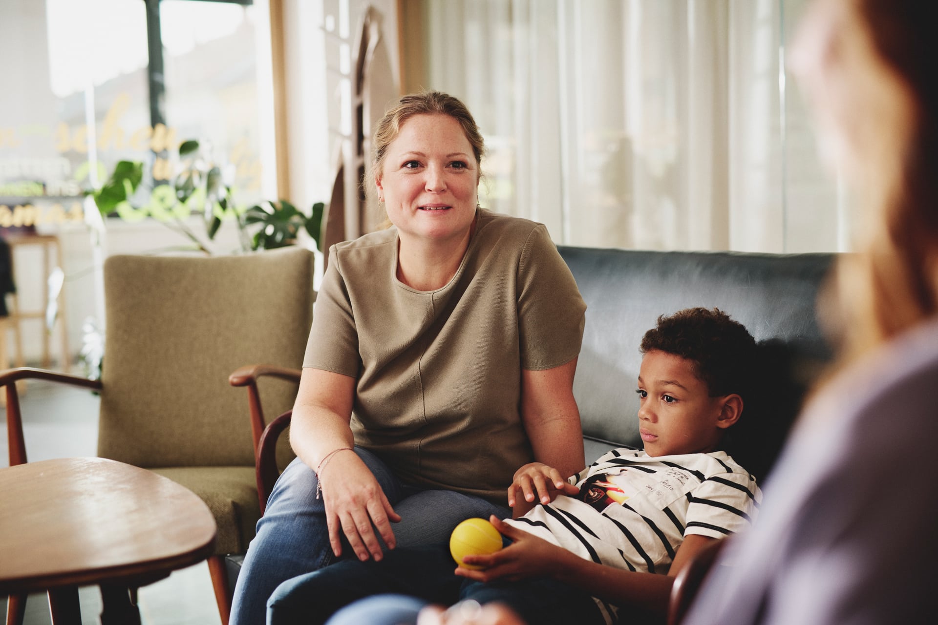Mutter mit jungem Sohn bei Familienberatungsgespräch, sprechen mit LebensgroßBeraterin