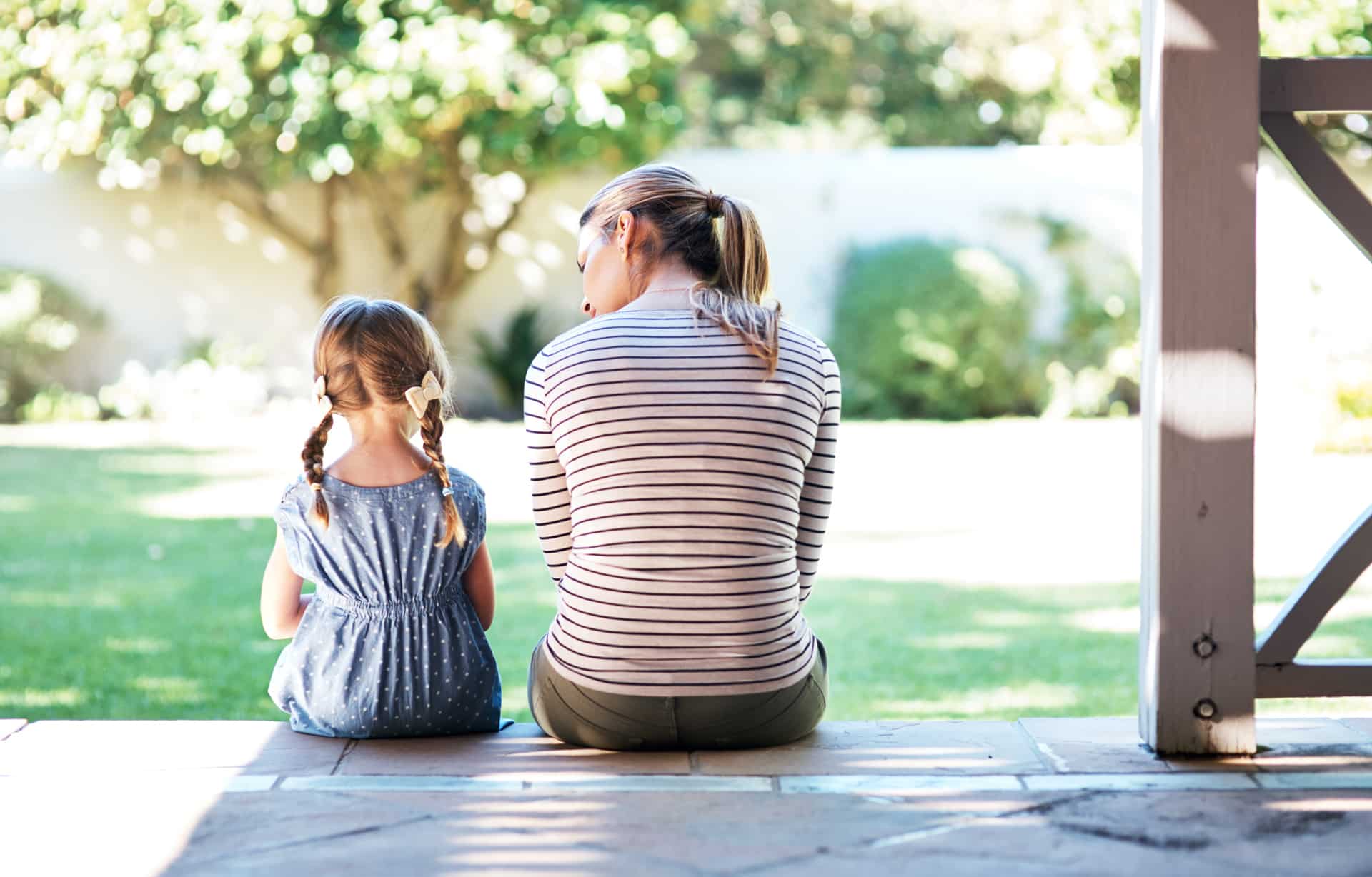 Beraterin spricht mit jungem Mädchen, sitzen mit Rücken auf Terrasse und unterhalten sich