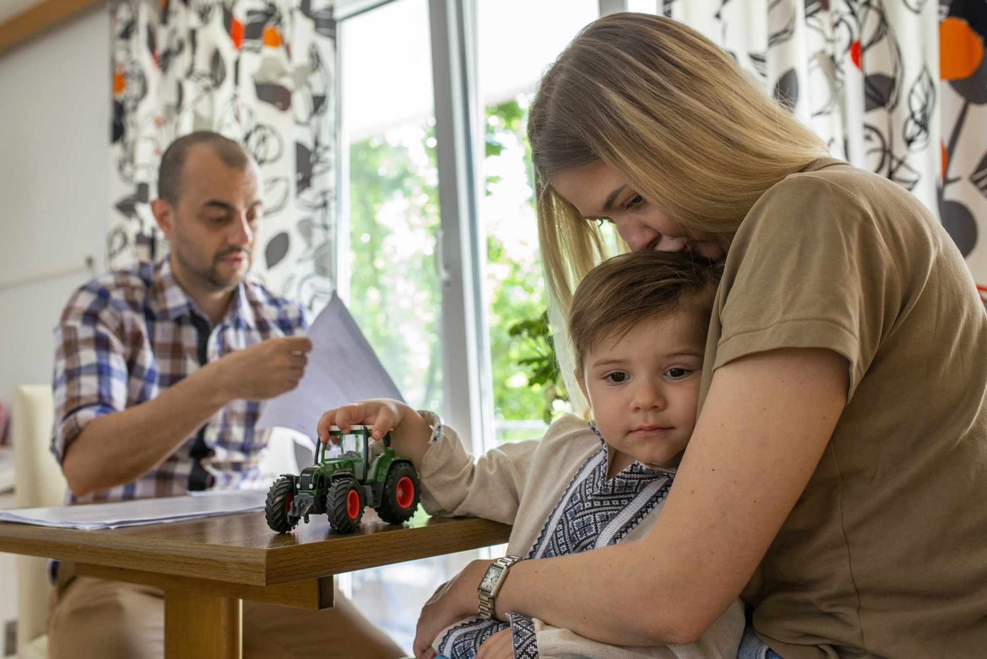 Lebensgroß Mitarbeiter hilft ukrainischer Mutter und ihrem Sohn bei behördlichen Dokumenten