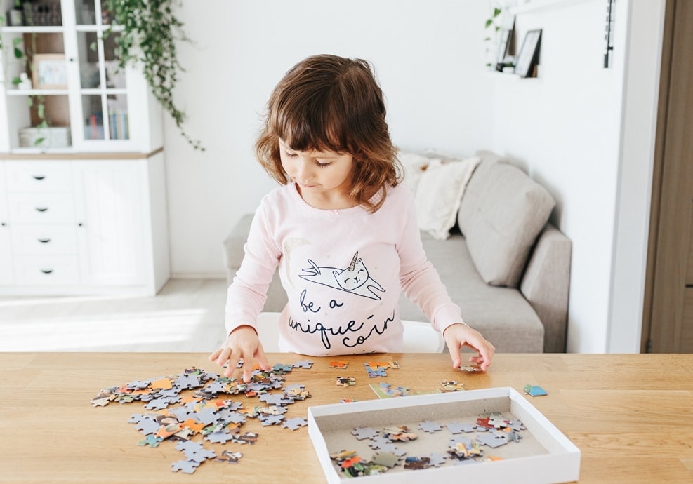 kleines Mädchen spielt mit Puzzle