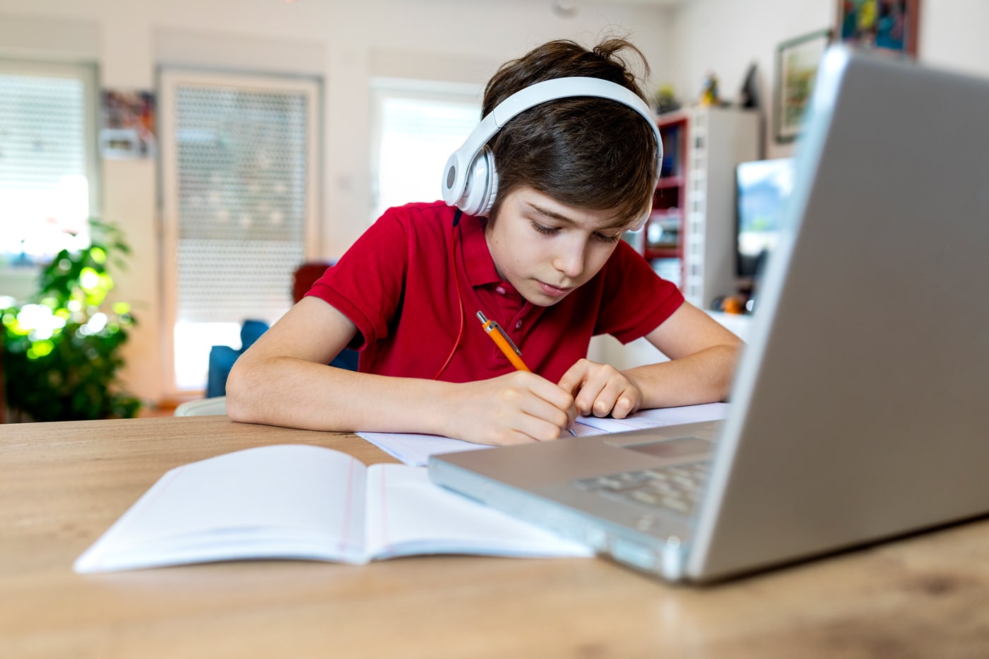 Schüler im Autismusspektrum mit Kopfhörern vor Laptop