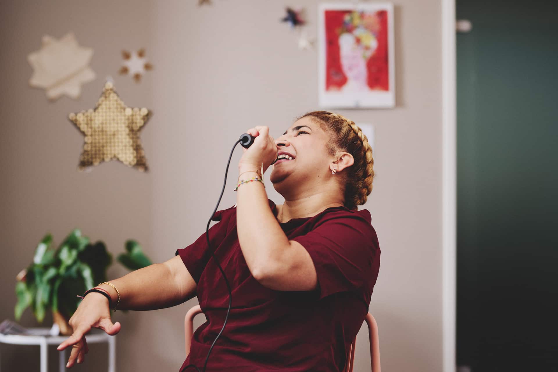 Junge Frau singt begeistert Karaoke und lebt selbstbestimmt in individueller Wohnform