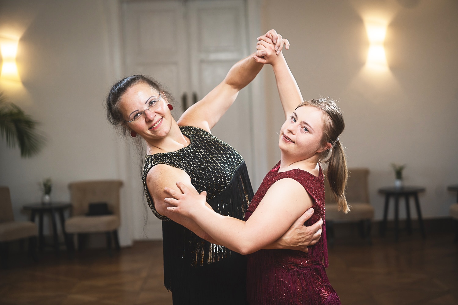 zwei Frauen tanzen miteinander in Ballkleidern
