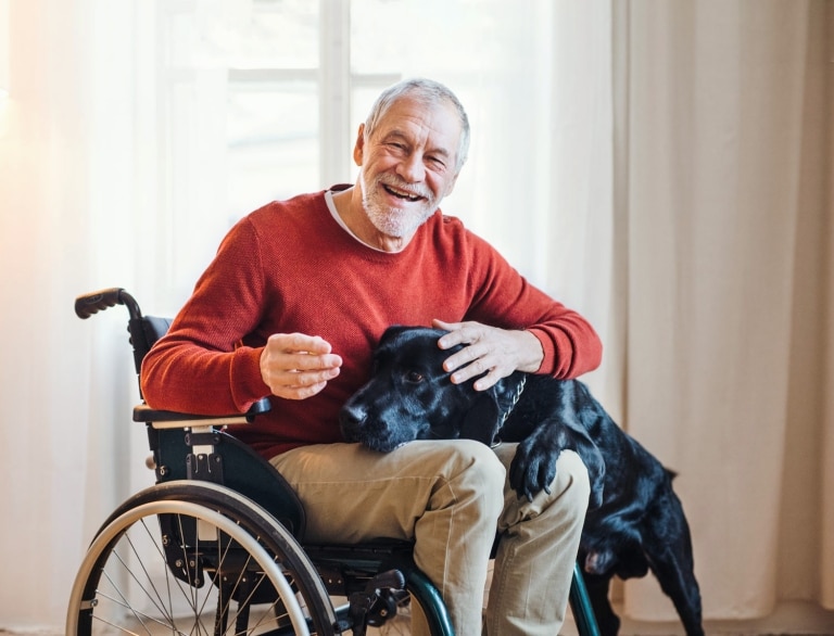 älterer Mann im Rollstuhl mit Hund